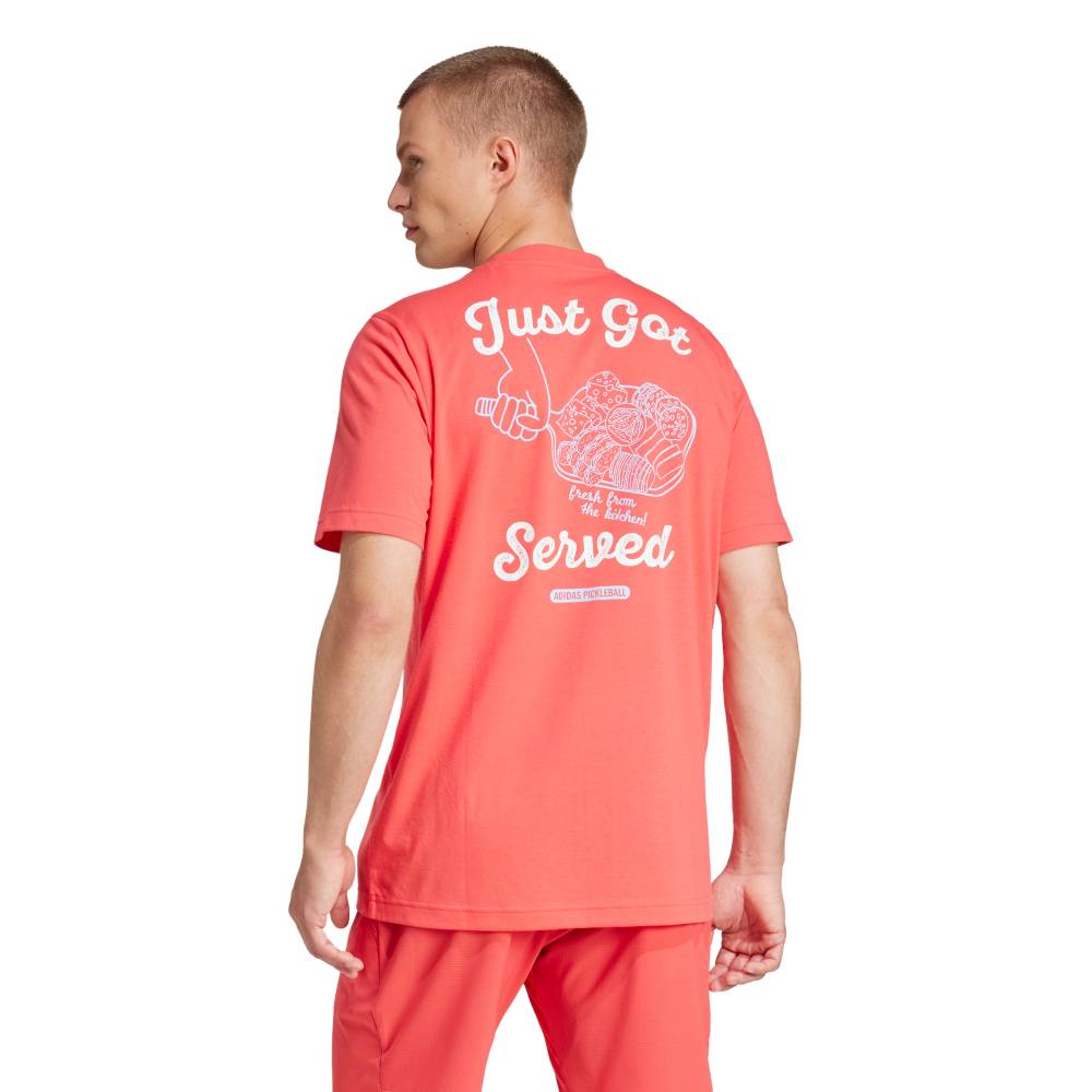 Person wearing a coral t-shirt with text and graphics on the back, standing against a white background